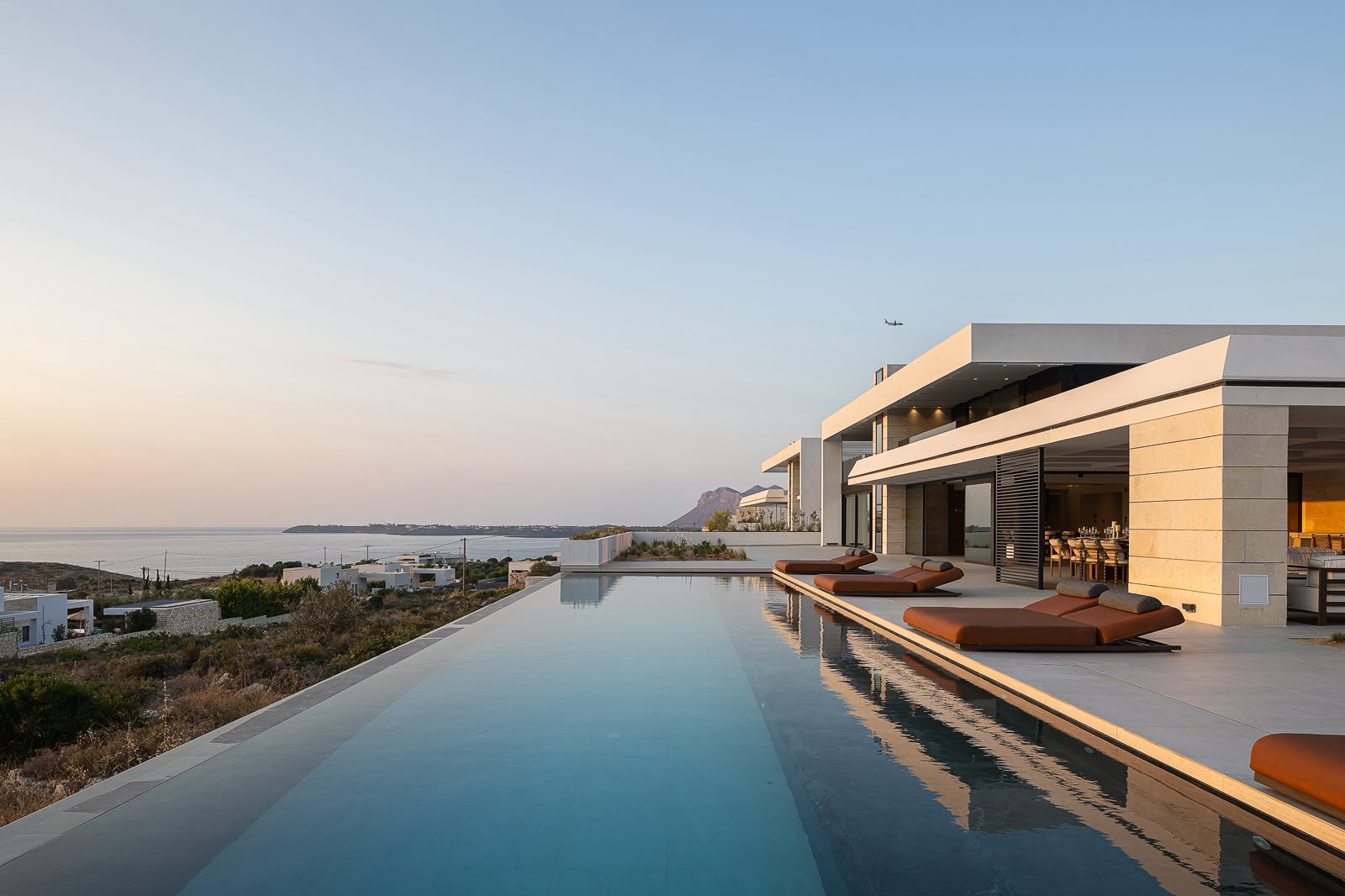 The infinity pool running the length of the house at dusk